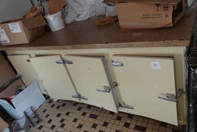 boxes are stacked on top of a kitchen counter in a cluttered room