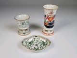 trois types de vases différents et une assiette posés sur une table