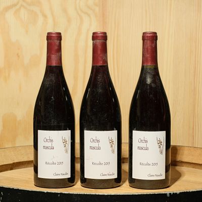 three bottles of wine sitting on top of a barrel