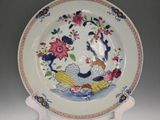 a plate with a bird and flowers on it