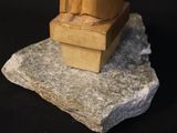 a statue of a man sitting on top of a rock