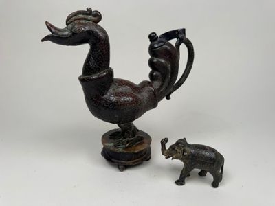 une petite statue représentant un oiseau et un éléphant, posée sur une table
