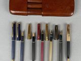 Plusieurs stylos et un étui sont alignés sur une table