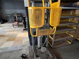 un panier jaune posé sur un support métallique