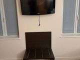 a tv mounted on the wall in a small room