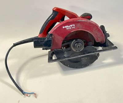 une scie circulaire rouge posée sur une surface blanche