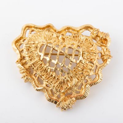 une image représentant une broche en forme de cœur ornée d'une croix