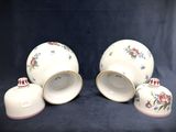 four pieces of white and red china with floral designs on them
