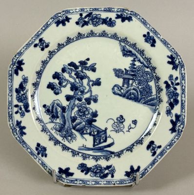 blue and white plate with a design of animals and flowers on it