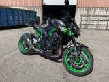 a black and green motorcycle parked in front of a building