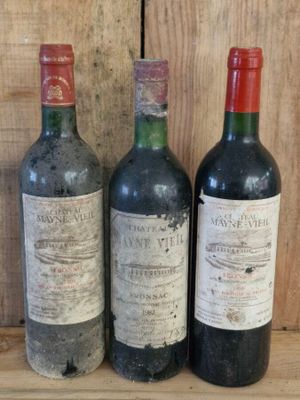 three bottles of wine sitting on a shelf next to each other