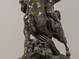 statue of a man riding a horse on a rock on a table