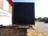 a large black box truck parked in front of a building