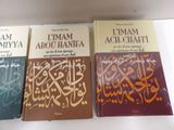 three books are sitting on a shelf in front of a white wall