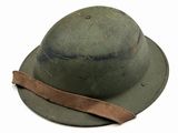 an old army helmet with a brown ribbon on a white background