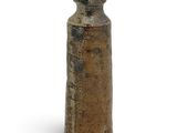 a brown vase that is sitting on a white surface