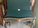 a black and gold chair with a green seat
