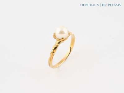 a close up of a gold ring with a pearl on it