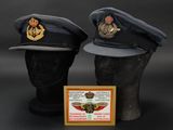 pair of military hats on display on a black background