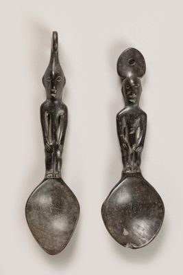 two silver spoons and a spoon with a statue on them