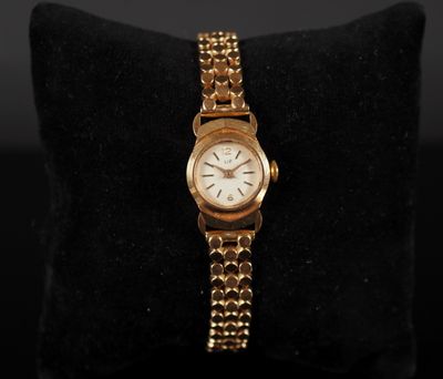 an image of a gold watch on a black cushion