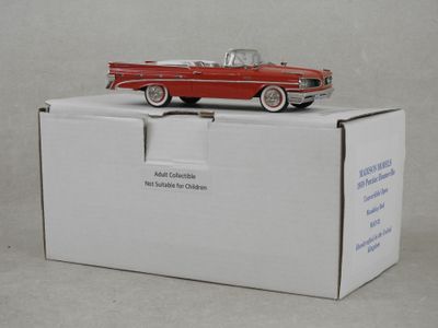 une petite voiture rouge posée sur une boîte blanche