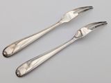 a pair of silverware forks and spoons on a table