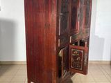 a wooden cabinet with a door open on a tiled floor