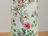 un vase blanc orné d'un oiseau et de fleurs