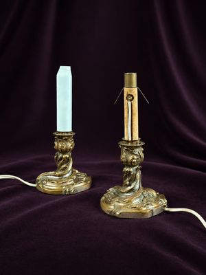 pair of antique brass candles on a purple velvet background