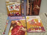 trois livres pour enfants posés sur un lit recouvert d'une couverture rayée