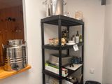 une étagère noire sur laquelle sont posés de nombreux objets