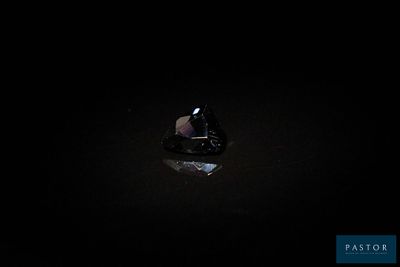 a black diamond in the dark with a reflection on the ground