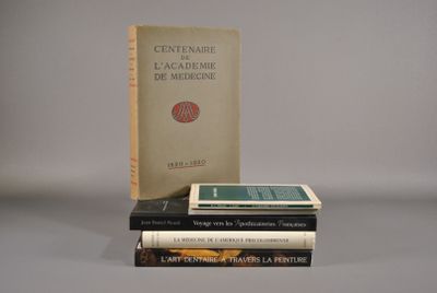 trois livres sont empilés sur une table