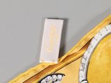 a yellow purse with a diamond ring on it