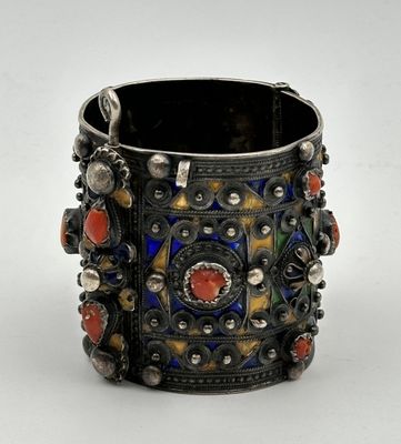 un gros plan sur un bracelet en argent orné de pierres colorées