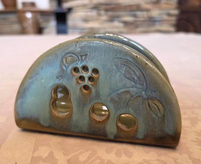 un petit objet métallique posé sur une table, avec un mur de pierre en arrière-plan