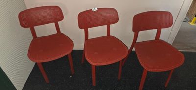 three red chairs sitting next to each other in a room