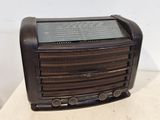une radio à l'ancienne posée sur une table près d'un mur blanc