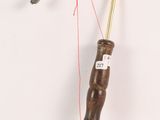 a small wooden object with a red string attached to it