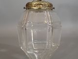 a small glass vase with a red bead hanging from it