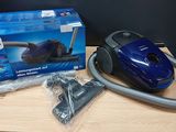 the blue vacuum is sitting on the table next to the box
