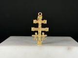 un gros plan d'une croix en or posée sur un socle blanc