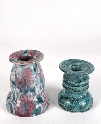 two vases sitting next to each other on a white surface