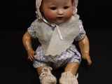 a small doll that is sitting on a black surface