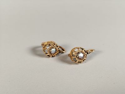 a pair of gold and pearl earrings on a white background