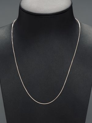 a white gold chain necklace on a mannequin neck