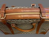 a brown and tan bag with a handle on a gray background