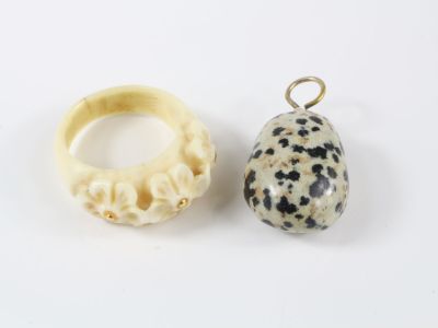un gros plan sur deux bijoux posés sur une surface blanche