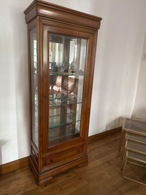 a wooden cabinet with a glass door in a room